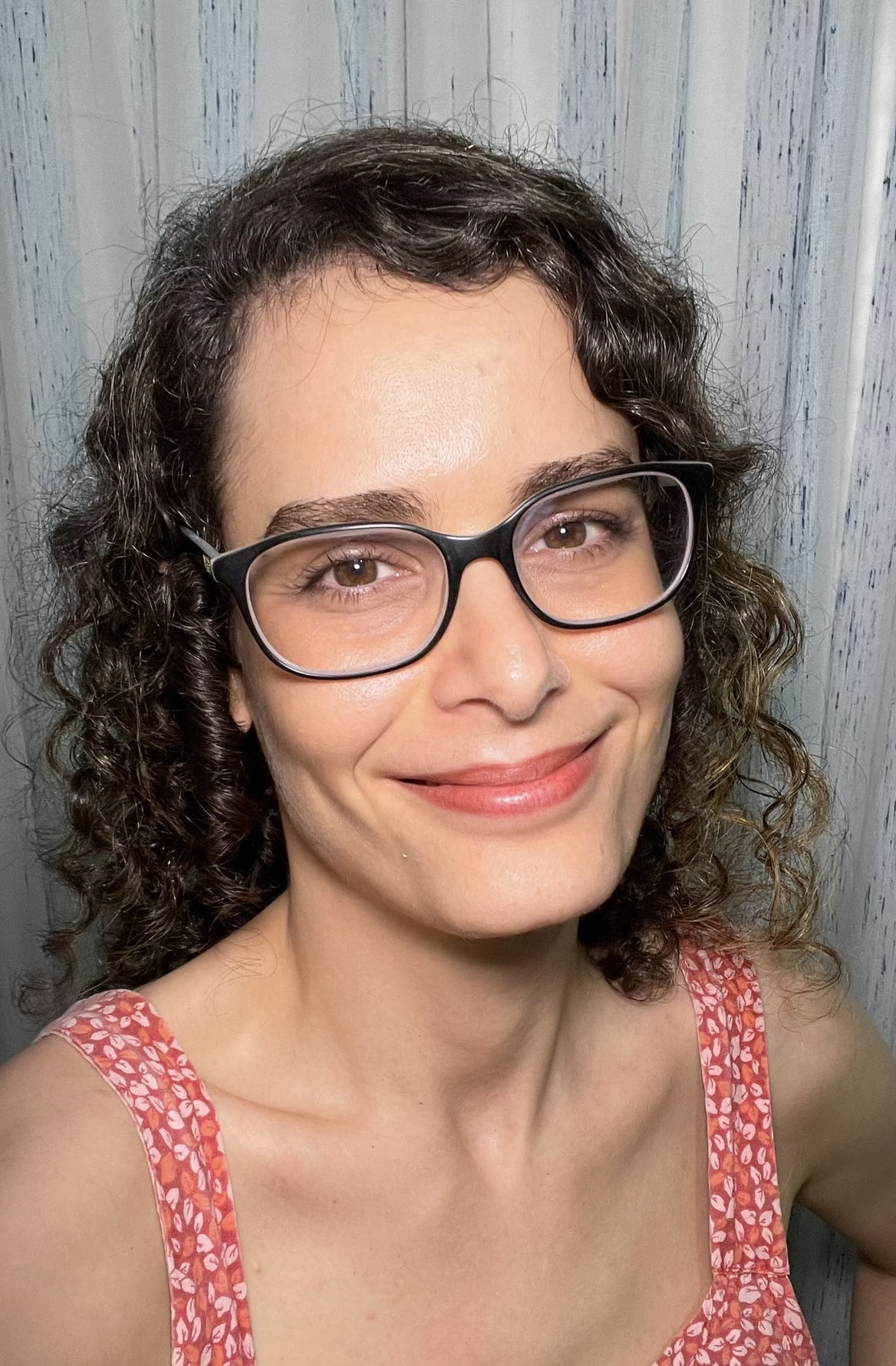 Luisa Ambros sorrindo, de óculos, em foto espontânea